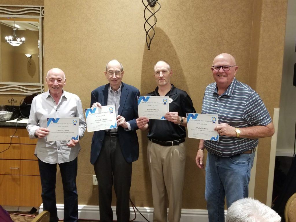 Four club members holding award certificates