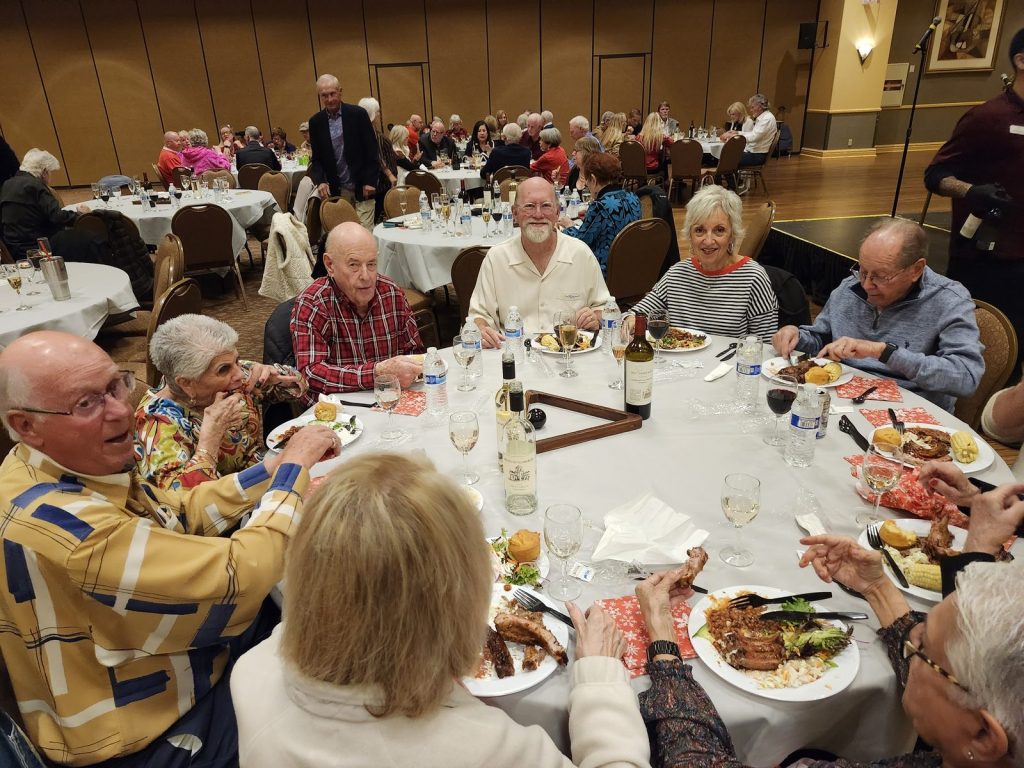 Members smiling around a dinner table at a club dinner