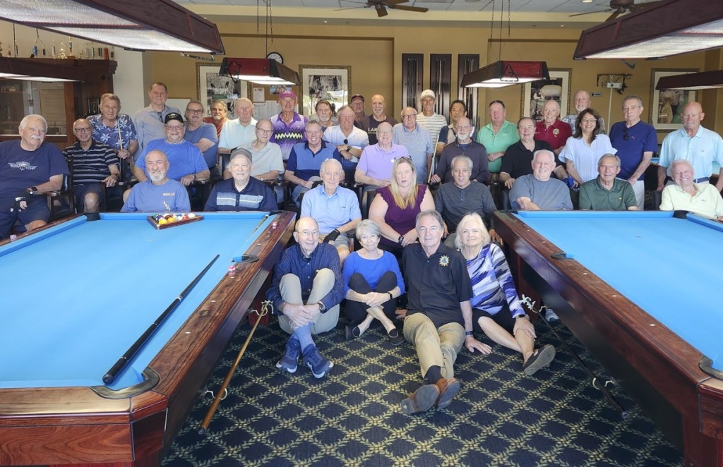 Club members gathered between two pool tables for the club group photo