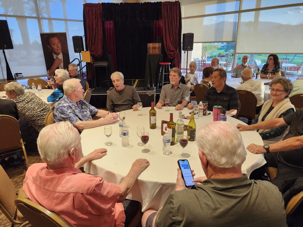 Members chatting around a table at a club social event