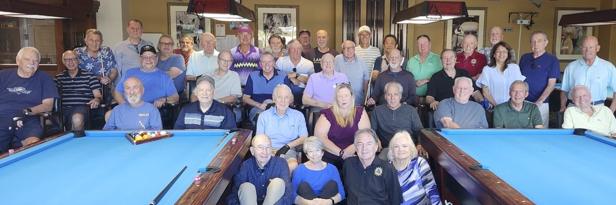 Club members gathered between two pool tables for the club group photo