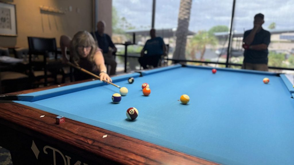 A member lines up a shot by the windows of the billiards hall